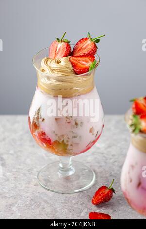 Dessert estivo freddo. Ciotole di gelatina stratificata servite sul tavolo su sfondo chiaro. Cocktail colorato e festoso con gelatina di dolci in vetro Foto Stock