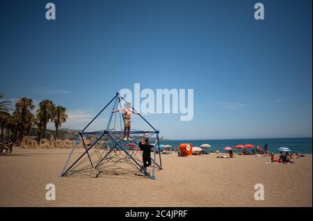 Malaga, Spagna. 27 Giugno 2020. Un uomo è visto sulla cima di una struttura a Malagueta spiaggia durante una calda estate day.A onda di calore attraversa il paese con alte temperature, secondo l'Agenzia Meteorologica Spagnola. Credit: Jesus Merida/SOPA Images/ZUMA Wire/Alamy Live News Foto Stock