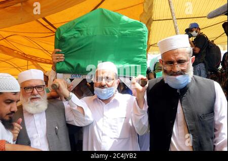 Un gran numero di persone partecipa alla preghiera funeraria dell'ex capo Giamaat-e-Islami (JI) Syed Munawar Hasan, che è stato allontanato in un ospedale locale dopo una prolungata malattia il venerdì sera, presso il terreno Eidgah situato nella zona di Nazimabad a Karachi sabato 27 giugno 2020. Sono presenti anche il capo Giamaat-e-Islami (JI) Siraj-ul-Haq insieme ad altri leader. Foto Stock