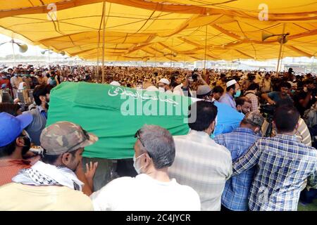 Un gran numero di persone partecipa alla preghiera funeraria dell'ex capo Giamaat-e-Islami (JI) Syed Munawar Hasan, che è stato allontanato in un ospedale locale dopo una prolungata malattia il venerdì sera, presso il terreno Eidgah situato nella zona di Nazimabad a Karachi sabato 27 giugno 2020. Sono presenti anche il capo Giamaat-e-Islami (JI) Siraj-ul-Haq insieme ad altri leader. Foto Stock