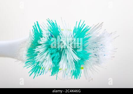 Spazzolino da denti su un tavolo bianco. Setole molto usurate in una spazzola per l'igiene personale. Sfondo chiaro. Foto Stock