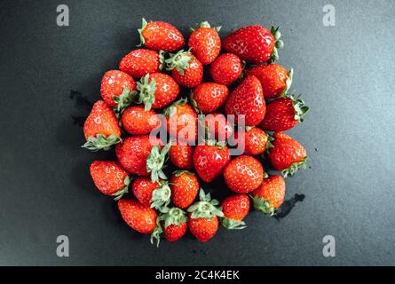 Fragole rosse raccolte di fresco su sfondo nero. Foto Stock