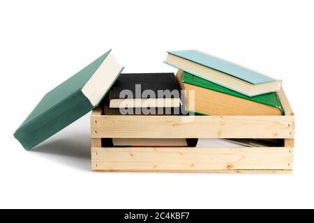 una collezione di libri antichi in una cassa di legno isolata su bianco Foto Stock