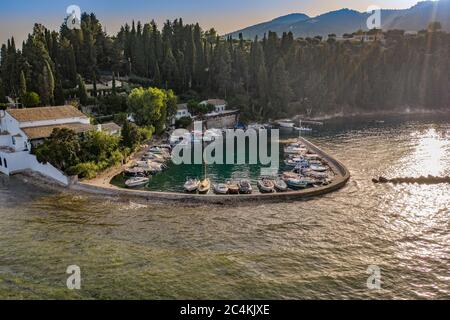 Foto aerea del piccolo porto e villaggio di pescatori di Kouloura con acque turchesi e cristalline, isola di Corfù, Ionio, Grecia Foto Stock