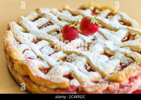 Torta di fragole appena sfornata con zucchero a velo e decorazione di fragole Foto Stock