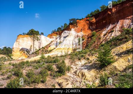 Belle colline rosse coperte di alberi della Provenza del Colorado a Rustrel, Francia Foto Stock