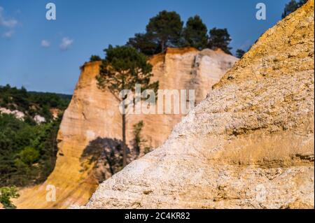 Belle colline rosse coperte di alberi della Provenza del Colorado a Rustrel, Francia Foto Stock