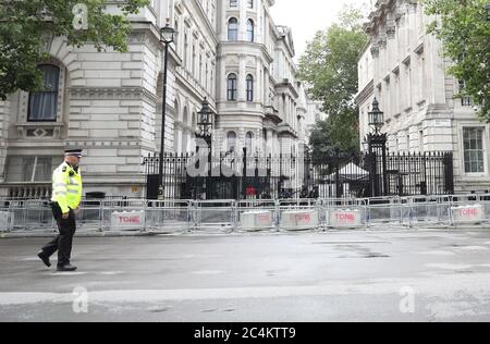 Londra, Regno Unito. 27 Giugno 2020. Un poliziotto cammina lungo Whitehall con Downing Street sullo sfondo, poiché le barriere sono già state messe in atto in caso di problemi che possono derivare da una qualsiasi delle proteste e raduni di oggi a Londra. Credit: Paul Marriott/Alamy Live News Foto Stock