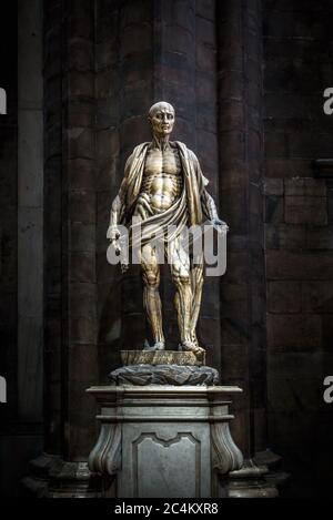 Milano - 16 maggio 2017: Statua di San Bartolomeo fiampata all'interno del famoso Duomo di Milano. Spaventosa statua gotica su sfondo scuro. Foto Stock