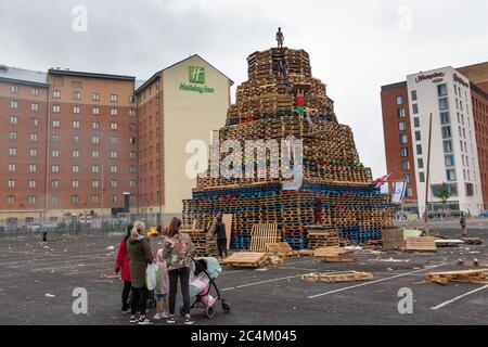 Uomo in piedi in cima a un falò Sandy Row, Belfast. Celebrazioni dell'undicesima notte. Foto Stock