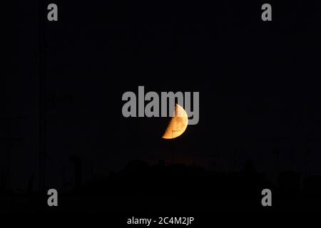 Ripresa notturna di una mezza luna rossa gigante Foto Stock