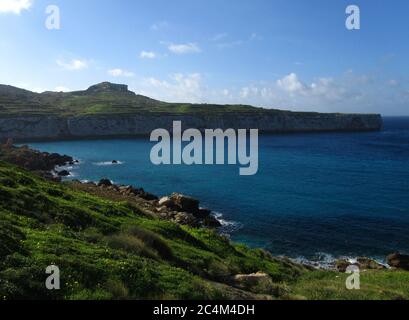 FOMM IR-RIH, RABAT, MALTA - 09 febbraio 2014: Una vista panoramica della baia di fomm ir-Rih e delle scogliere costiere di Malta, con il mare blu, il cielo nuvoloso e l'orizzonte. Foto Stock