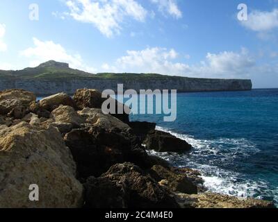 FOMM IR-RIH, RABAT, MALTA - 09 febbraio 2014: Una vista panoramica della baia di fomm ir-Rih e delle scogliere costiere di Malta, con il mare blu, il cielo nuvoloso e l'orizzonte. Foto Stock