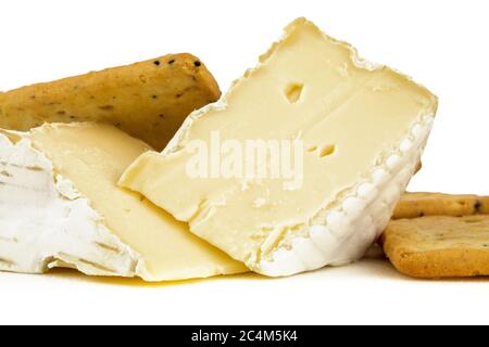 closeup estremo di due spicchi di formaggio brie con cracker multigenali isolati su bianco Foto Stock