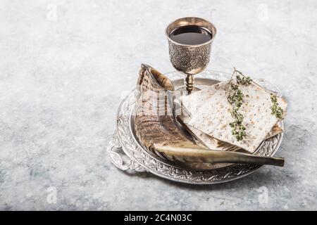 Pasqua, la Festa del pane azzimo, pane matzah e bicchieri di vino rosso sul piatto di metallo rotondo e brillante. Pasqua. Vino kosher rosso con matza bianco Foto Stock