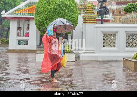 Vendita di mappe presso un'attrazione turistica di Bangkok, in una giornata di pioggia. Foto Stock