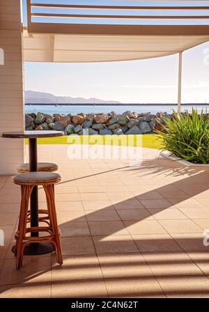 Tavolo da bar e sgabelli in ambiente esterno vicino al mare Foto Stock