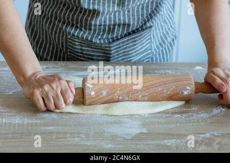 stendere la pasta di lievito con un rullo di pasta di legno Foto Stock