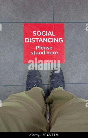 Segno di distanza sociale sul pavimento del negozio, Cambridgeshire Foto Stock