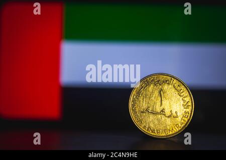 Dirham degli Emirati Arabi Uniti - una moneta di Dirham degli Emirati Arabi Uniti isolata sullo sfondo della bandiera degli Emirati Arabi Uniti. Moneta UAE 1 dirham moneta con spazio per il testo Foto Stock