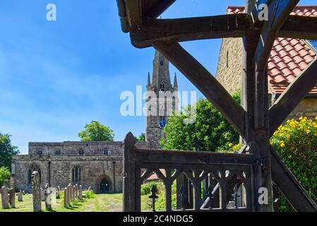 Chiesa di San Pietro nel villaggio di Harrold, Bedfordshire, Regno Unito visto attraverso la lichgate Foto Stock