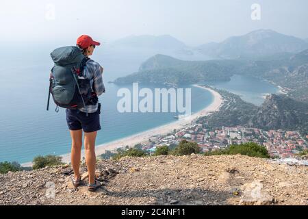 Giovane donna gode della vista della Laguna Blu a Oludeniz, Turchia. Camminando lungo il sentiero escursionistico Lycian Way nella regione di Antalya Foto Stock