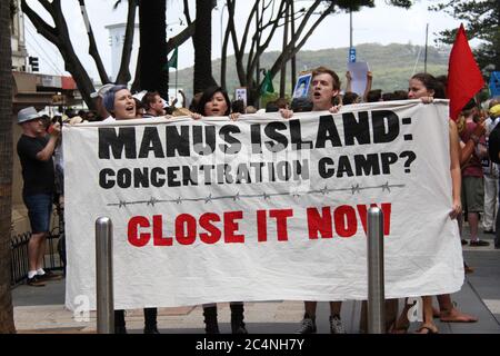 I manifestanti cantano a sostegno dei rifugiati mentre hanno un cartello con su scritto: ‘Manus Island concentration camp? Chiuderlo ora». Foto Stock