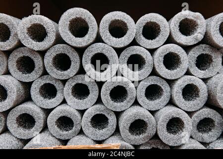 Isolamento impilato per tubi in polietilene espanso in magazzino. Foto Stock