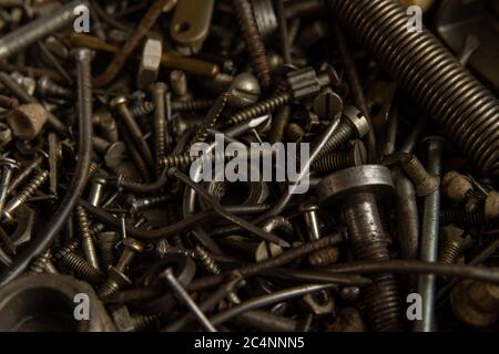 Gamma di Rusty vecchie viti bulloni dadi. Metallo grunge dettagli hardware nackground scuro Foto Stock