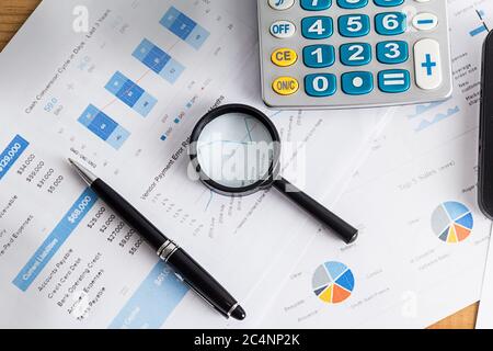 Analisi finanziaria per soluzioni concept carte a penna e grafici lente di ingrandimento vetro Foto Stock