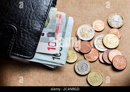Concetto di controllo delle finanze personali con monete da portafoglio e banconote Foto Stock