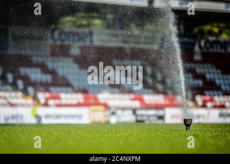 L'irrigatore ad acqua spruzza getto d'acqua sul campo da calcio Foto Stock