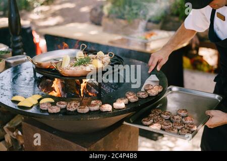 Lo chef prepara polpette per mini hamburger alla griglia. Foto Stock