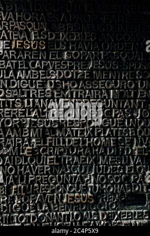 Dettaglio con la parola Gesù sulla porta di bronzo della facciata della Passione della Sagrada Familia a Barcellona. Le porte del Vangelo contengono testo del nuovo Testamento Foto Stock