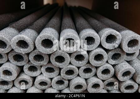 Isolamento impilato per tubi in polietilene espanso in magazzino. Foto Stock