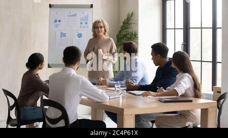 Guida fiduciosa di una donna d'affari di mezza età che conduce la riunione aziendale Foto Stock