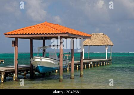 Barca sospesa in un molo, San Pedro Beach, San Pedro, Ambergris Caye, Belize Foto Stock