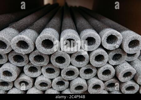 Isolamento impilato per tubi in polietilene espanso in magazzino. Foto Stock