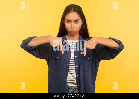 Qui e ora! Ritratto di ragazza in camicia denim che punta le dita verso il basso, ordine e controllo, risultato impegnativo immediatamente, concetto di autorità. Foto Stock