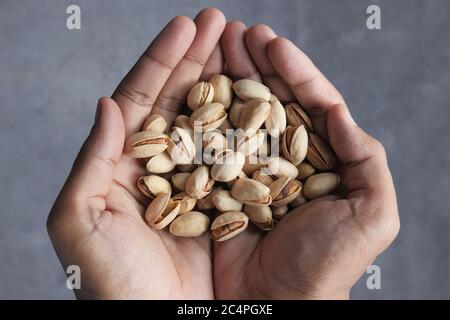 primo piano di pistacchi a mano Foto Stock