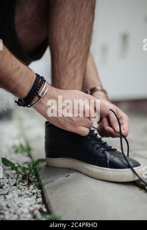 Giovane ragazzo urbano legando la sua scarpa su come prepararsi a. vai Foto Stock