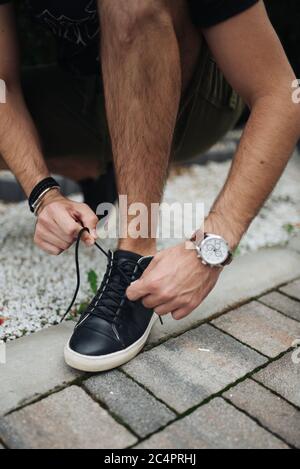 Giovane ragazzo urbano legando la sua scarpa su come prepararsi a. vai Foto Stock