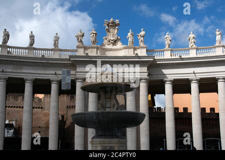 Statue di santi in cima ai colonnati dorici e fontana in granito disegnata dal Bernini in Piazza San PeterÕs, Città del vaticano, Vaticano Foto Stock