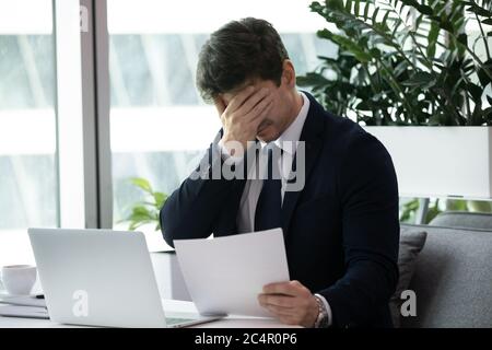 Frustrato uomo d'affari triste ottenuto sparato o notifica bunkruttcy Foto Stock