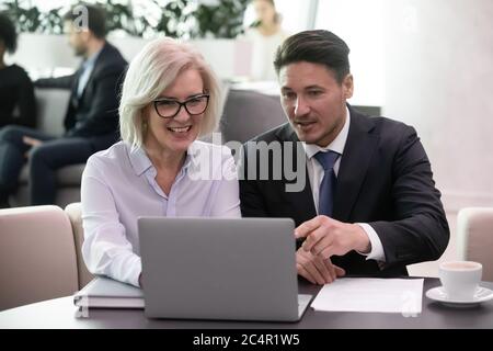 Uomo d'affari e donna colleghi che guardano un notebook sorridente felice Foto Stock