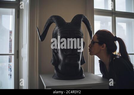 Ragazza che baciano la testa della scultura Foto Stock