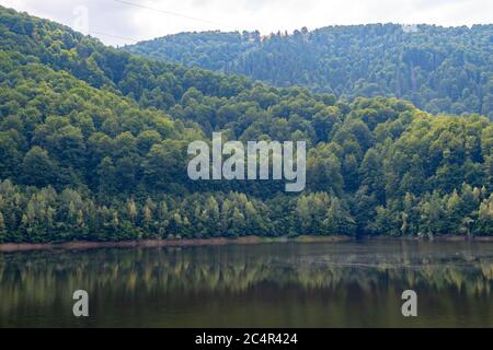 tramonto sul lago in montagna dove si trovano barche e barche da pesca Foto Stock