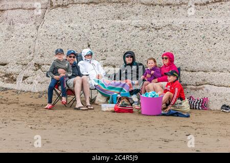 Garretstown, Cork, Irlanda. 28 Giugno 2020. Le famiglie Coveney e Marron si sono tutte avvolte e riparate in una fresca giornata estiva sulla spiaggia di Garrettstown, Co. Cork, Irlanda. I Coveney avrebbero dovuto volare in Portogallo per le loro vacanze in famiglia oggi, ma il viaggio è stato annullato a causa della crisi del Covid-19. LtoR; Seán e Pat Coveney, Mary e Rory Marron, Niamh, Caitriona e Padraig Coveney si sono avvolti in una fresca giornata estiva sulla spiaggia di Garrettstown, Co. Cork, Irlanda. - Credit David Creedon / Alamy Live News Foto Stock