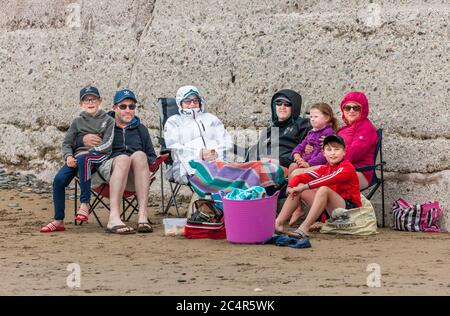 Garretstown, Cork, Irlanda. 28 Giugno 2020. Le famiglie Coveney e Marron si sono tutte avvolte e riparate in una fresca giornata estiva sulla spiaggia di Garrettstown, Co. Cork, Irlanda. I Coveney avrebbero dovuto volare in Portogallo per le loro vacanze in famiglia oggi, ma il viaggio è stato annullato a causa della crisi del Covid-19. LtoR; Seán e Pat Coveney, Mary e Rory Marron, Niamh, Caitriona e Padraig Coveney si sono avvolti in una fresca giornata estiva sulla spiaggia di Garrettstown, Co. Cork, Irlanda. - Credit David Creedon / Alamy Live News Foto Stock