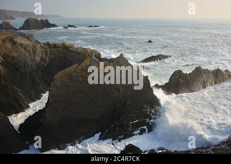 Scogliere rocciose e onde a Hartland Quay, North Devon, Regno Unito Foto Stock